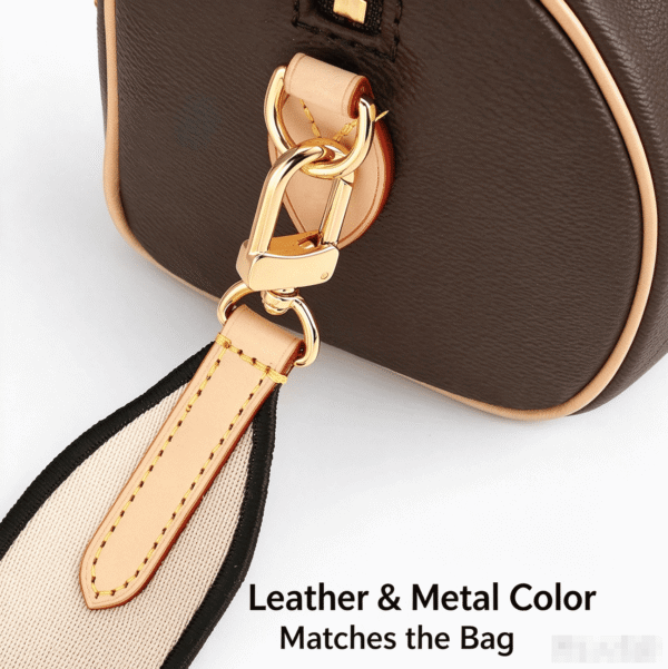 leather-metal-color-matching-gold-hardware-speedy-bag-strap Gold hardware and leather color matching Speedy handbag, premium metal clasp, vegetable tanned leather detail, decorative canvas shoulder strap connection.