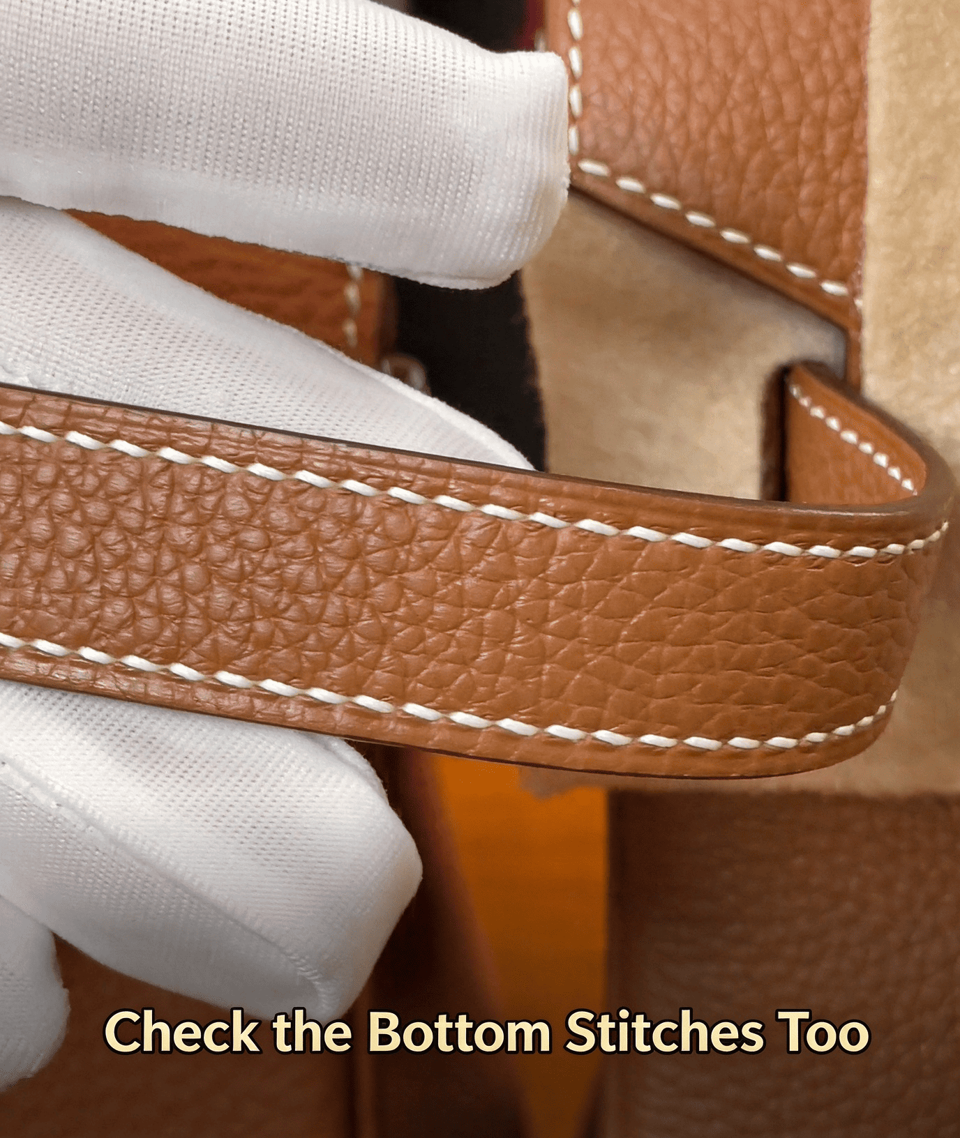 Check the bottom stitches too, brown leather strap white stitching, white glove holding luxury bag part, leather craftsmanship inspection, sewing technique detail